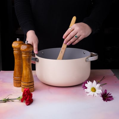 Stirring the contents of a pot, with salt and pepper shakers nearby.