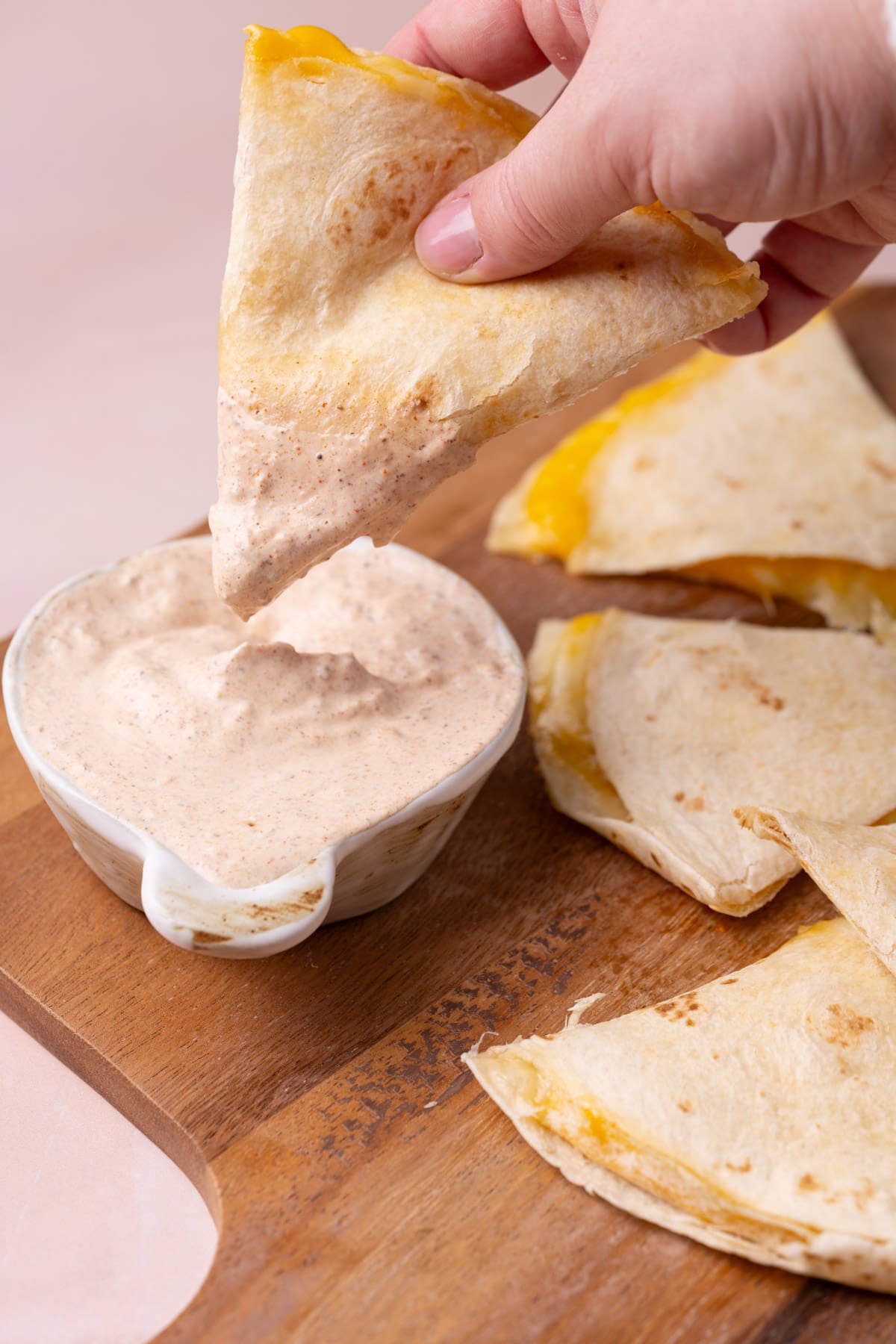 Dipping a piece of a cheese quesadilla into homemade sauce.