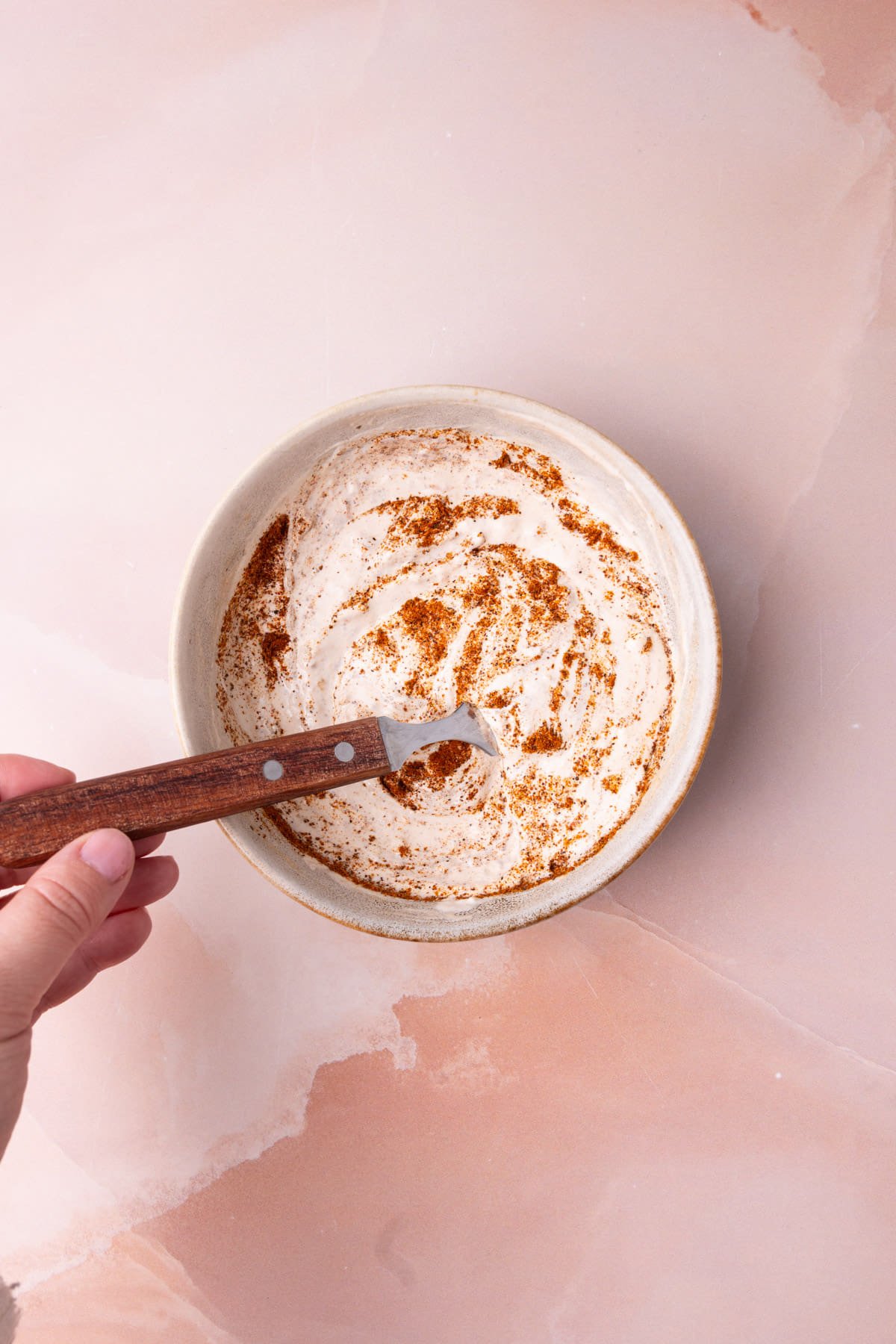 Mixing together sour cream, salsa, and taco seasoning to make a dipping sauce for quesadillas.