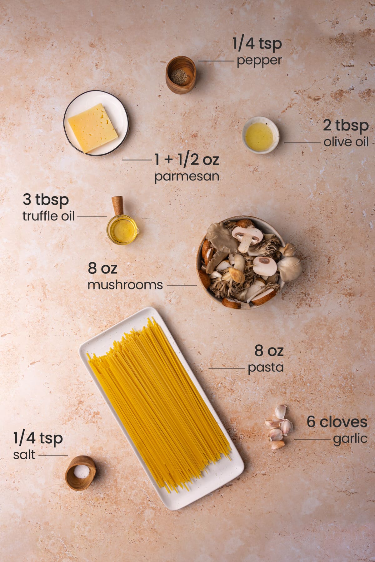 All ingredients needed for Truffle Oil Pasta including pepper, Parmesan, olive oil, truffle oil, mushrooms, pasta, garlic, and salt.