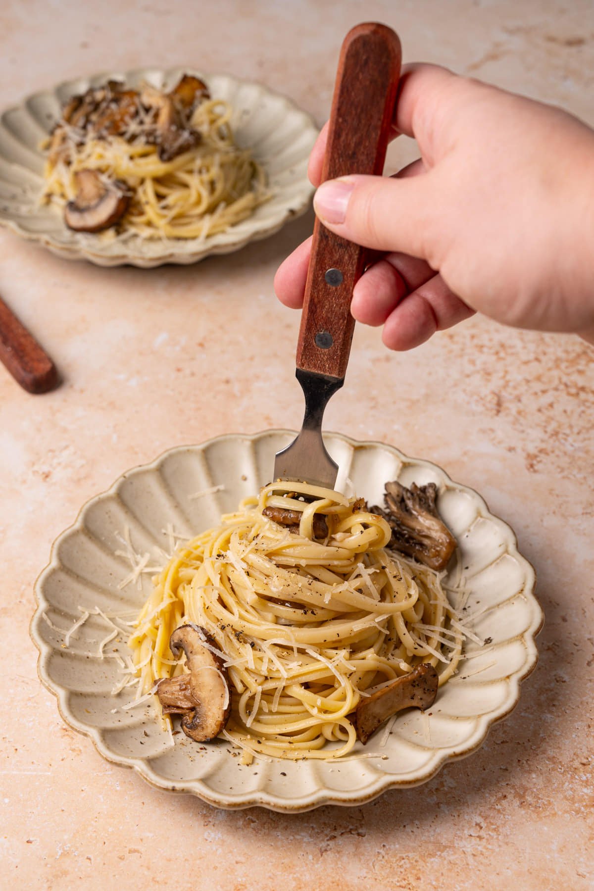 Twirling fork into plate of pasta with truffle oil.