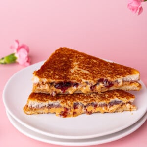 Two halves of a crispy toasted peanut butter and jelly sandwich stacked on top of one another.