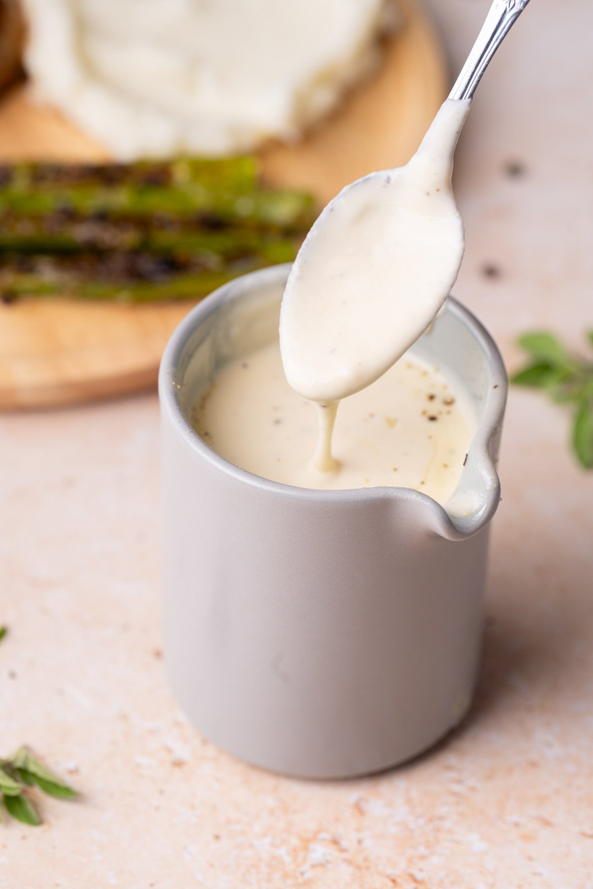 Creamy garlic Parm sauce dripping off of spoon. 