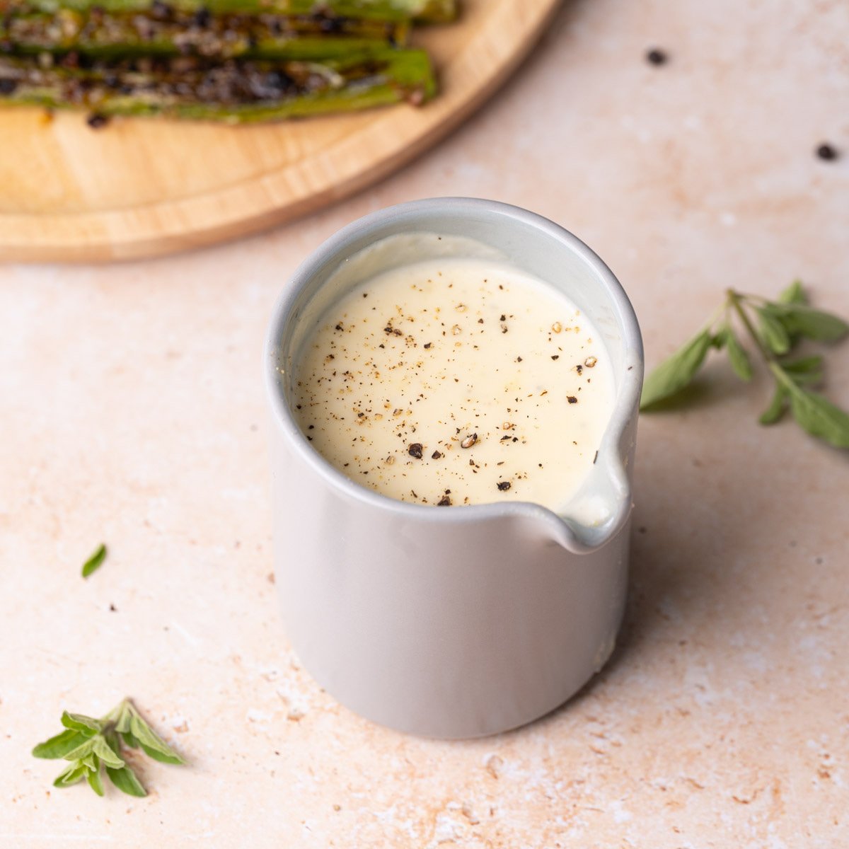 Small pitcher full of creamy Parmesan Garlic Sauce.