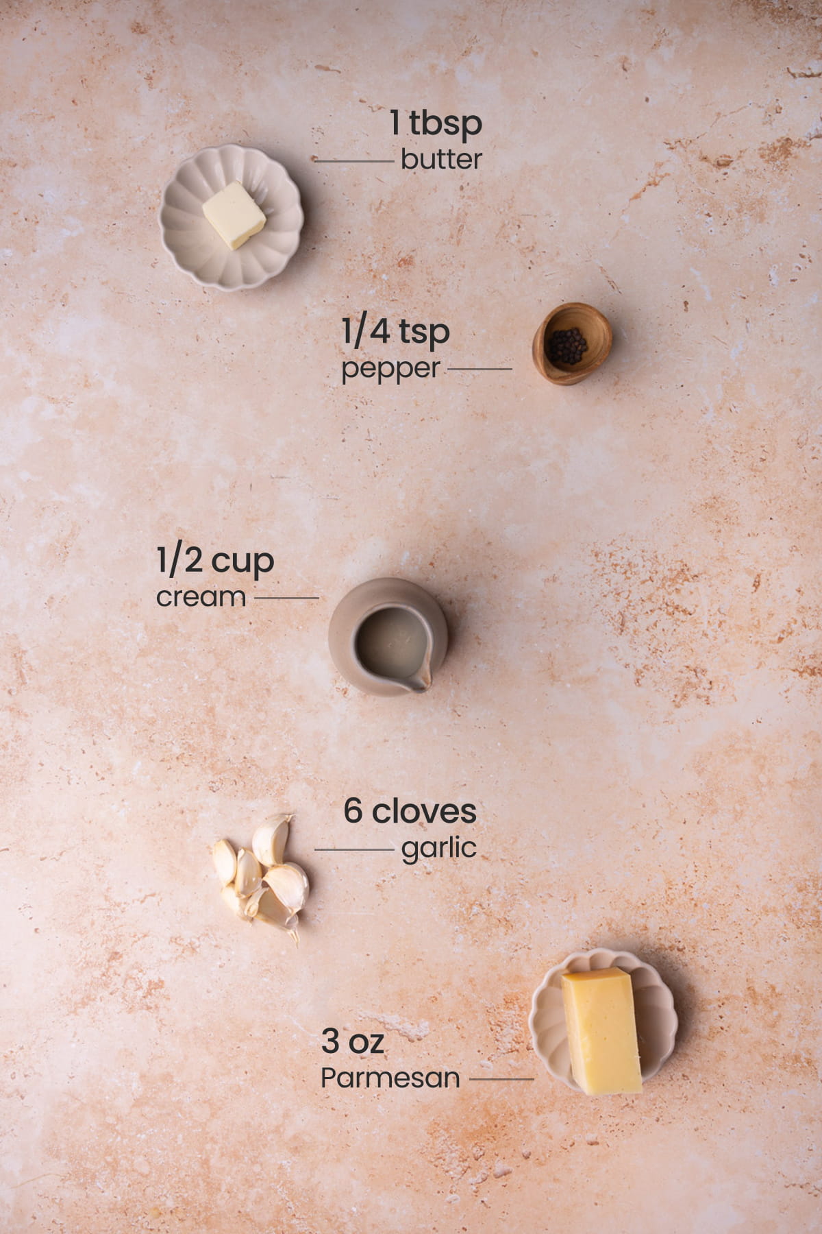 All ingredients needed to make Garlic Parmesan Sauce including butter, black pepper, cream, garlic, and Parmesan. 
