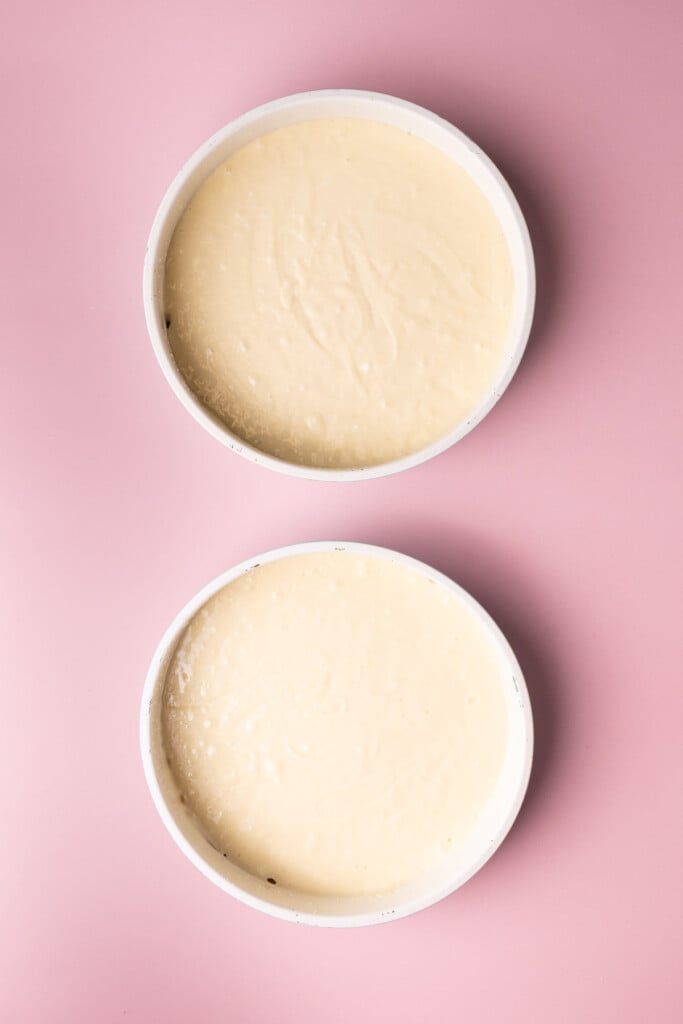 Elevated box cake mix batter in two 9-inch round cake pans ready to bake. 