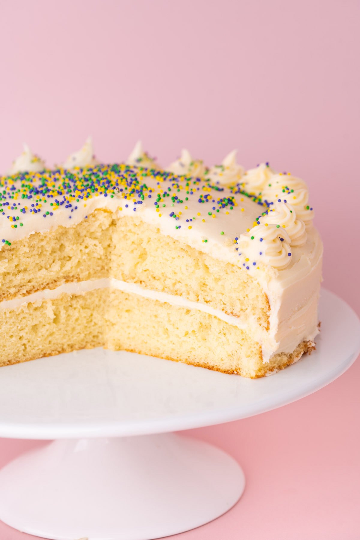 Layered white cake made from adding sour cream and vanilla extra to cake mix sliced open to see interior. 