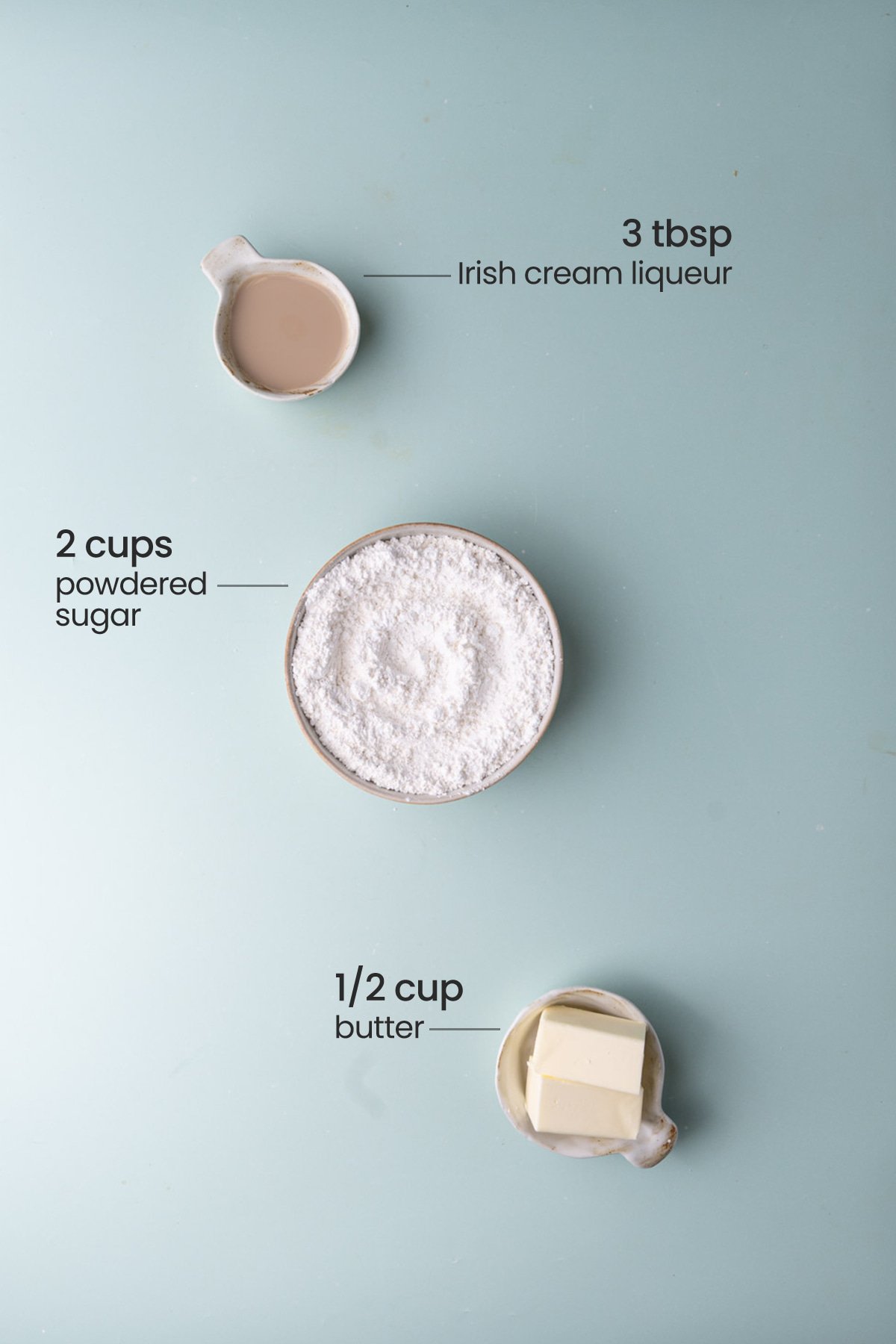 All ingredients needed for Irish Cream Buttercream including Irish Cream, powdered sugar, and unsalted butter. 