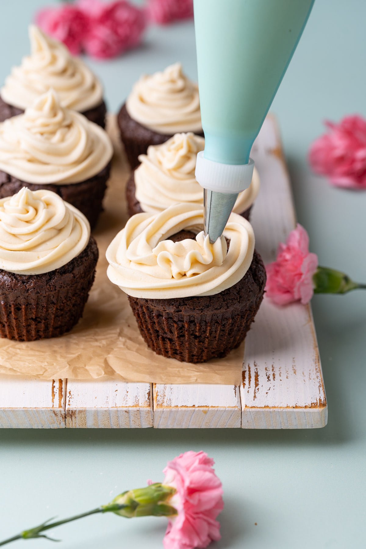 Piping Buttercream with Irish Cream onto a chocolate cupcake. 