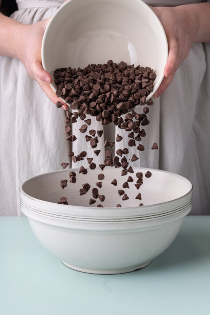 Adding milk chocolate chips to a large mixing bowl. 