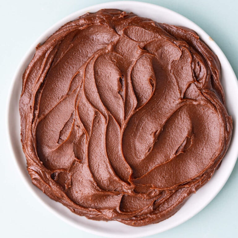 Close up of a small plate with swirls of milk chocolate ganache on it.