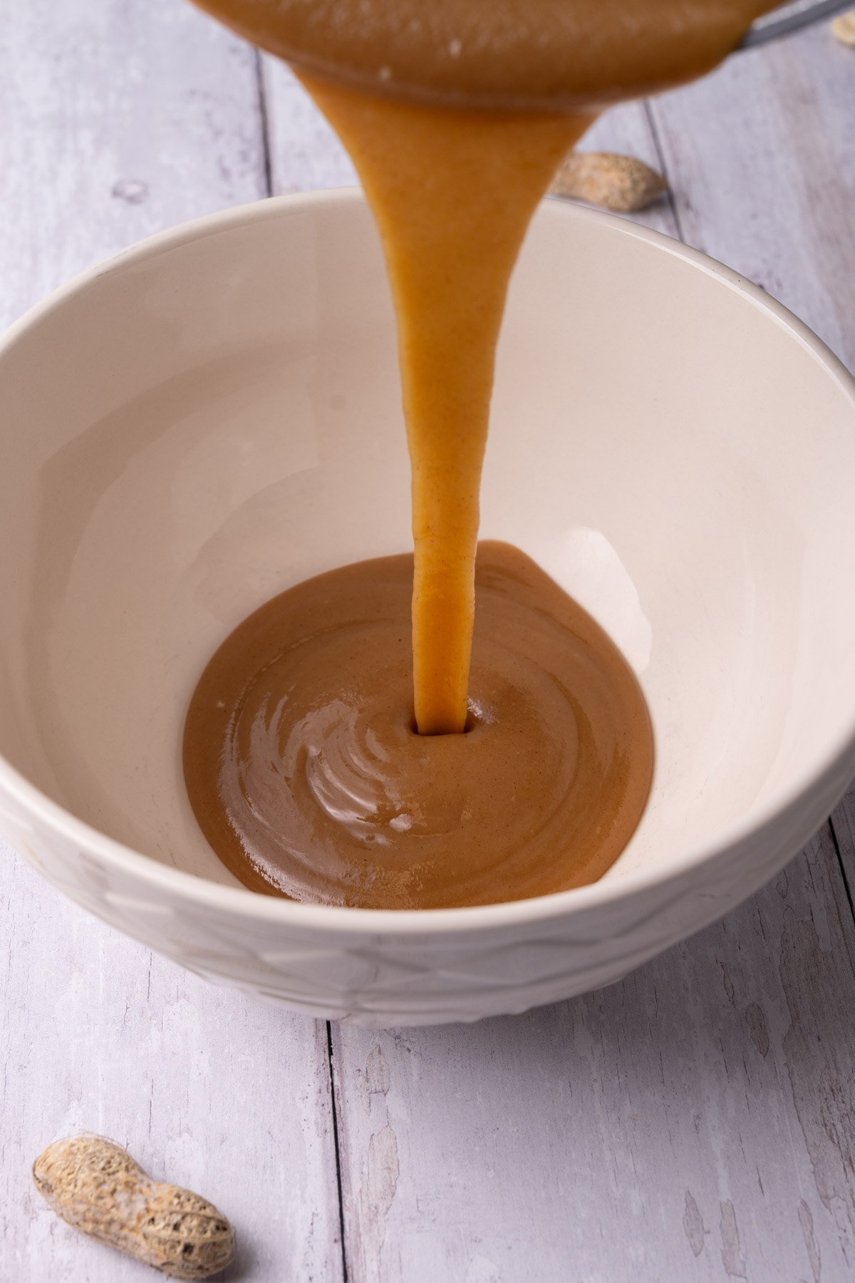 Pouring ganache with peanut butter into a bowl to allow it to cool and set. 