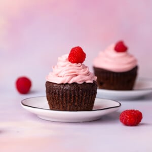 Chocolate cupcakes with homemade raspberry buttercream frosting topped with a fresh raspberry.