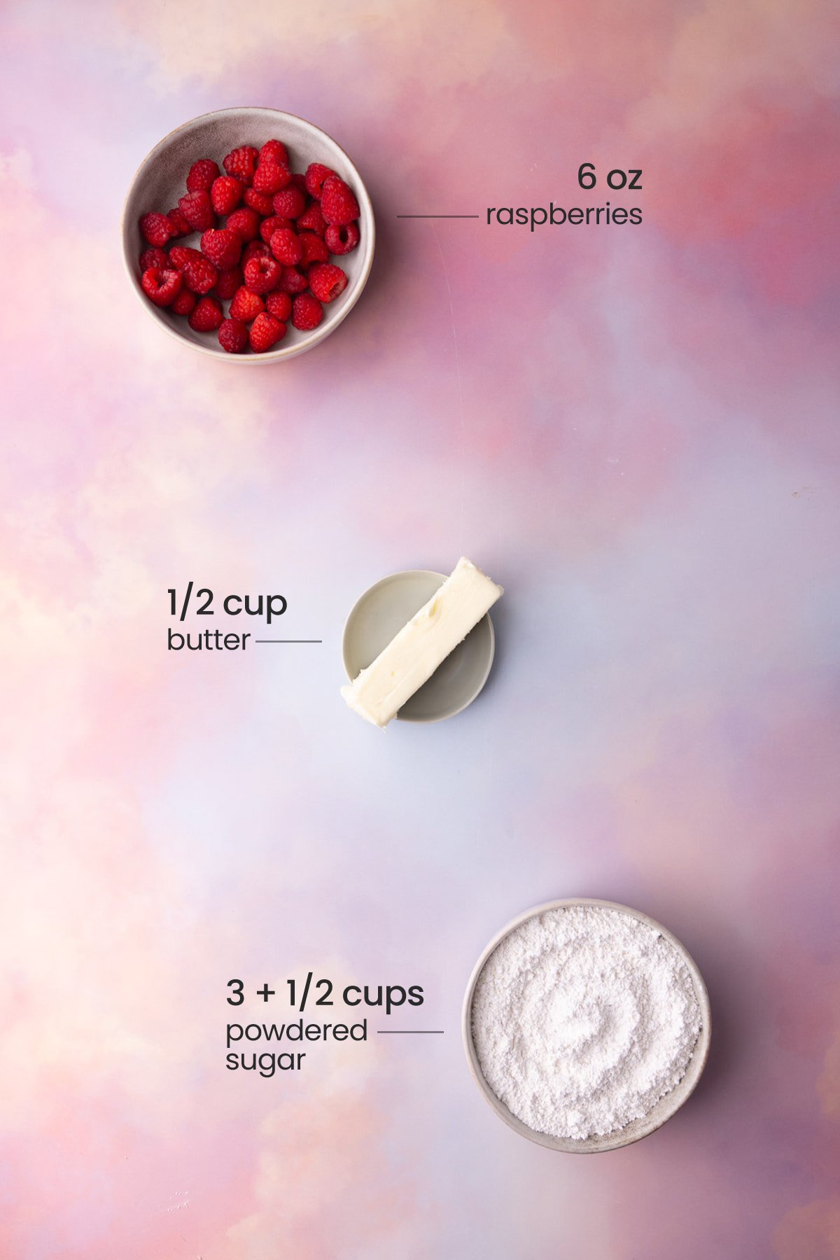 Overhead view of all the ingredients needed for raspberry buttercream - raspberries, butter, and powdered sugar.