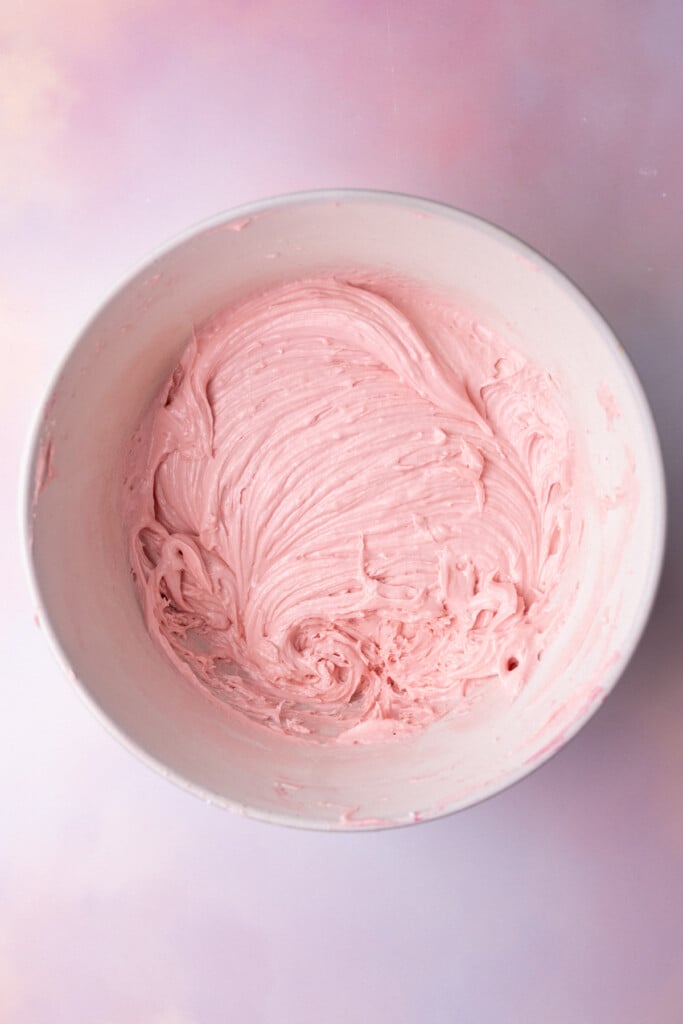 Pink buttercream in a mixing bowl made from fresh raspberries. 