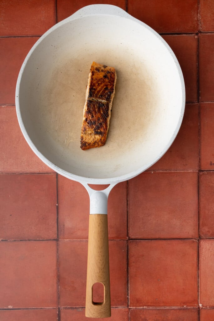 Searing salmon in olive oil in a frying pan over medium heat.