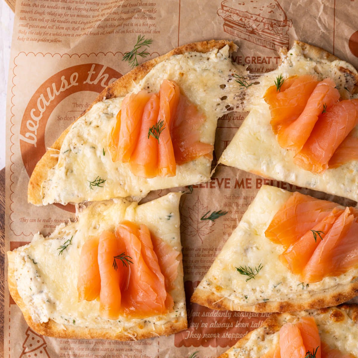 Close up of cheesy flatbread with smoked salmon sliced.