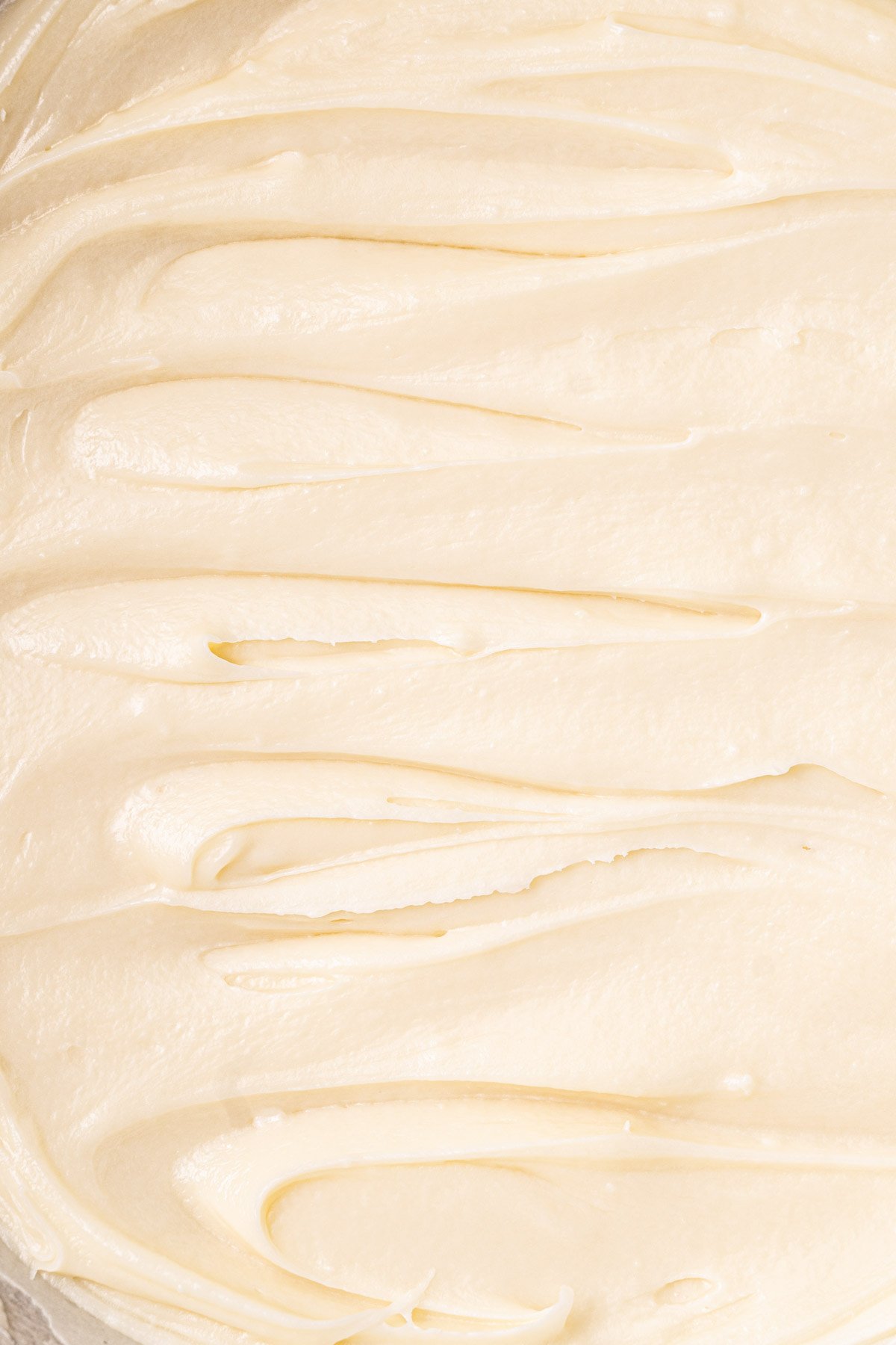 Close up of spreadable white ganache made with white chocolate chips and cream.
