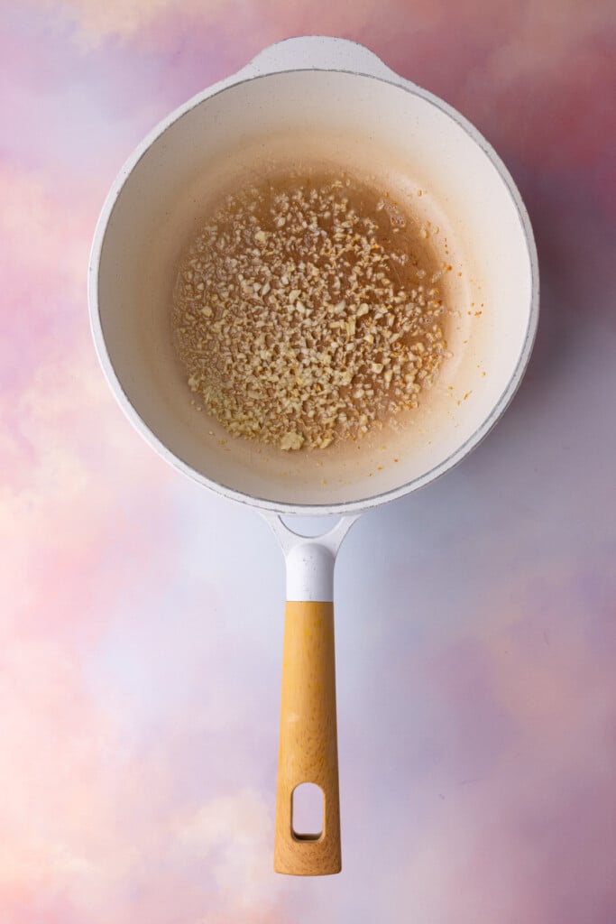 Cooking garlic in butter until soft so it seamlessly blends into cream sauce. 