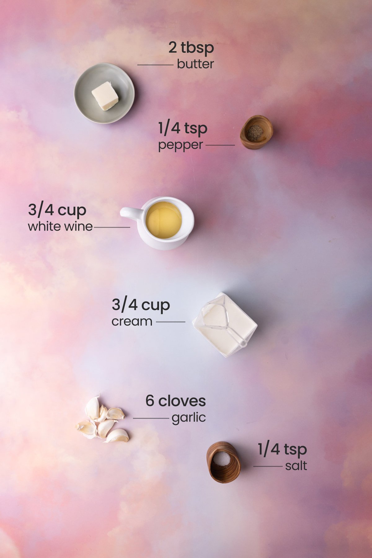 Overhead view of all the ingredients needed for white wine cream sauce - butter, pepper, white wine, cream, garlic, and salt.