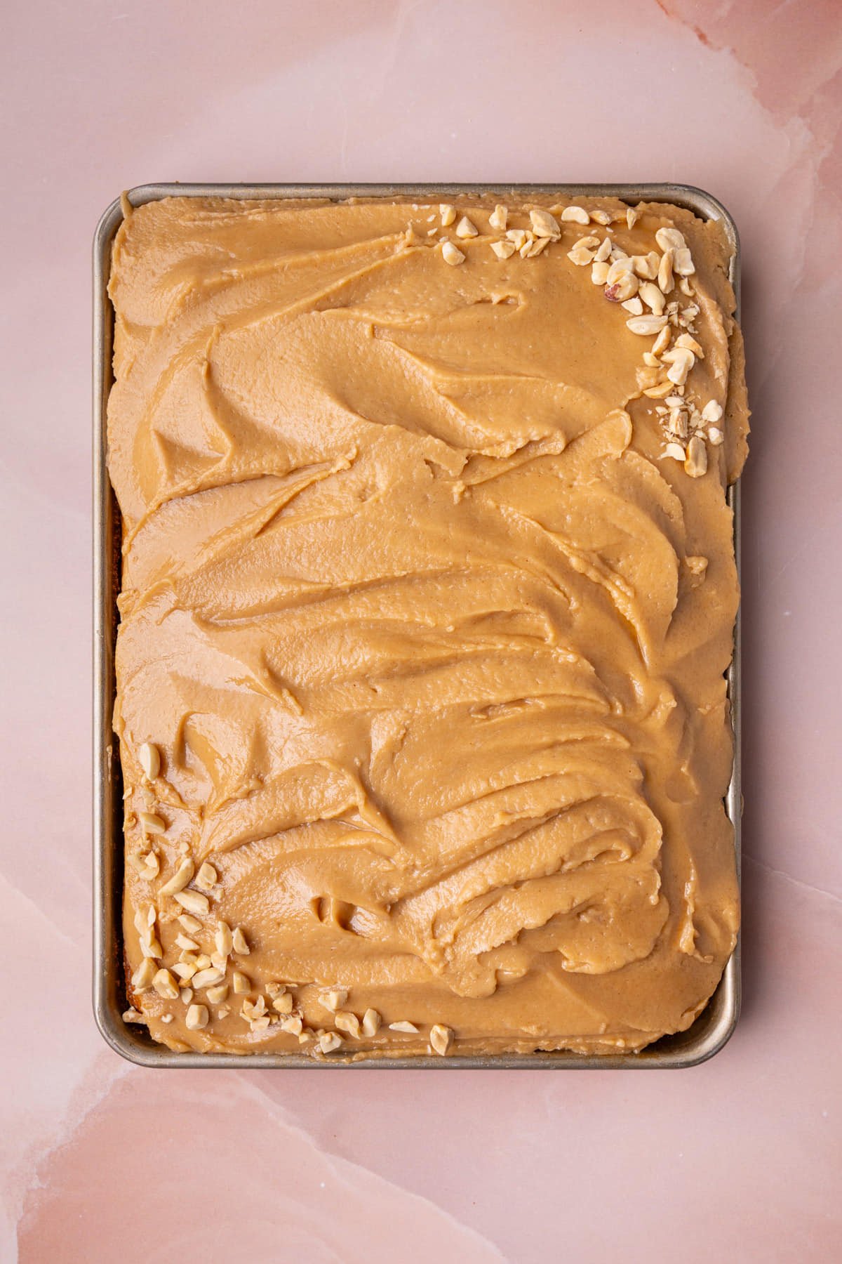 Peanut butter sheet cake with peanut butter frosting still in the sheet pan. 