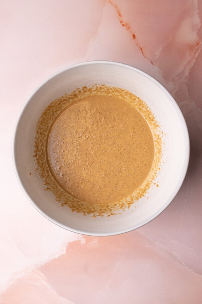Creamy peanut butter, oil, and brown sugar creamed together in a large mixing bowl. 