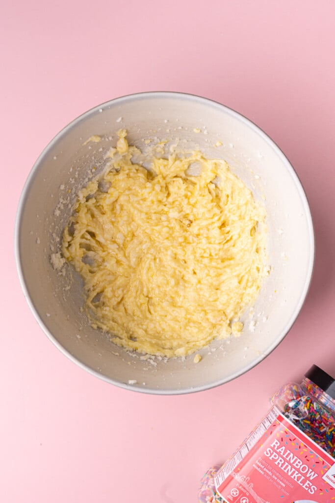 Sugar, butter, egg, and vanilla extract combined together in a large mixing bowl. 