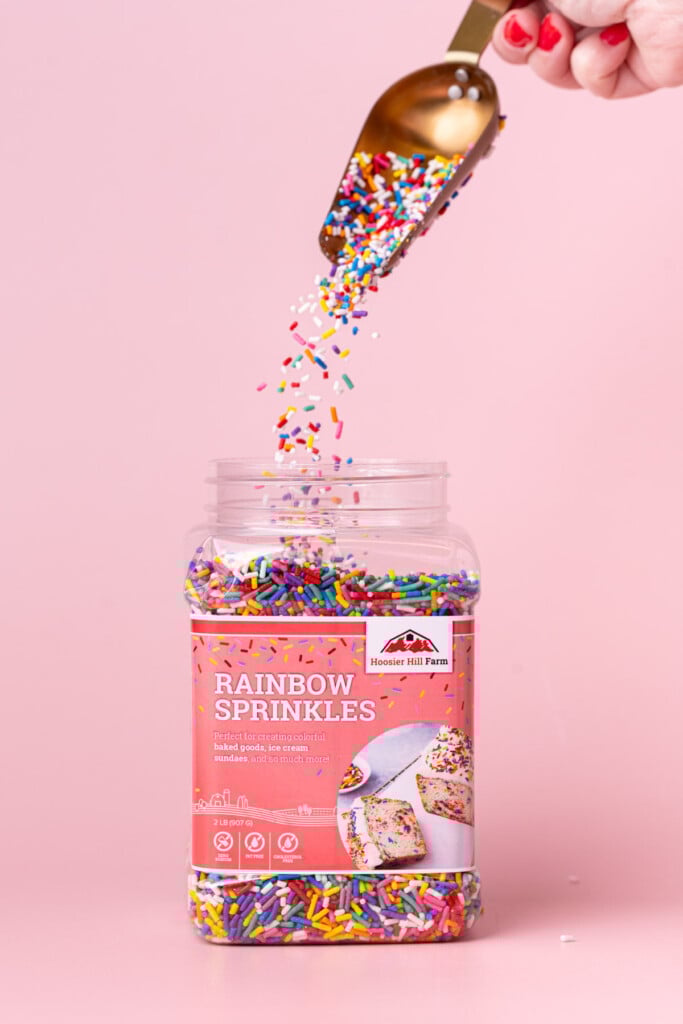 Pouring a handful of Hoosier Hill Farm rainbow sprinkles back into the jar.