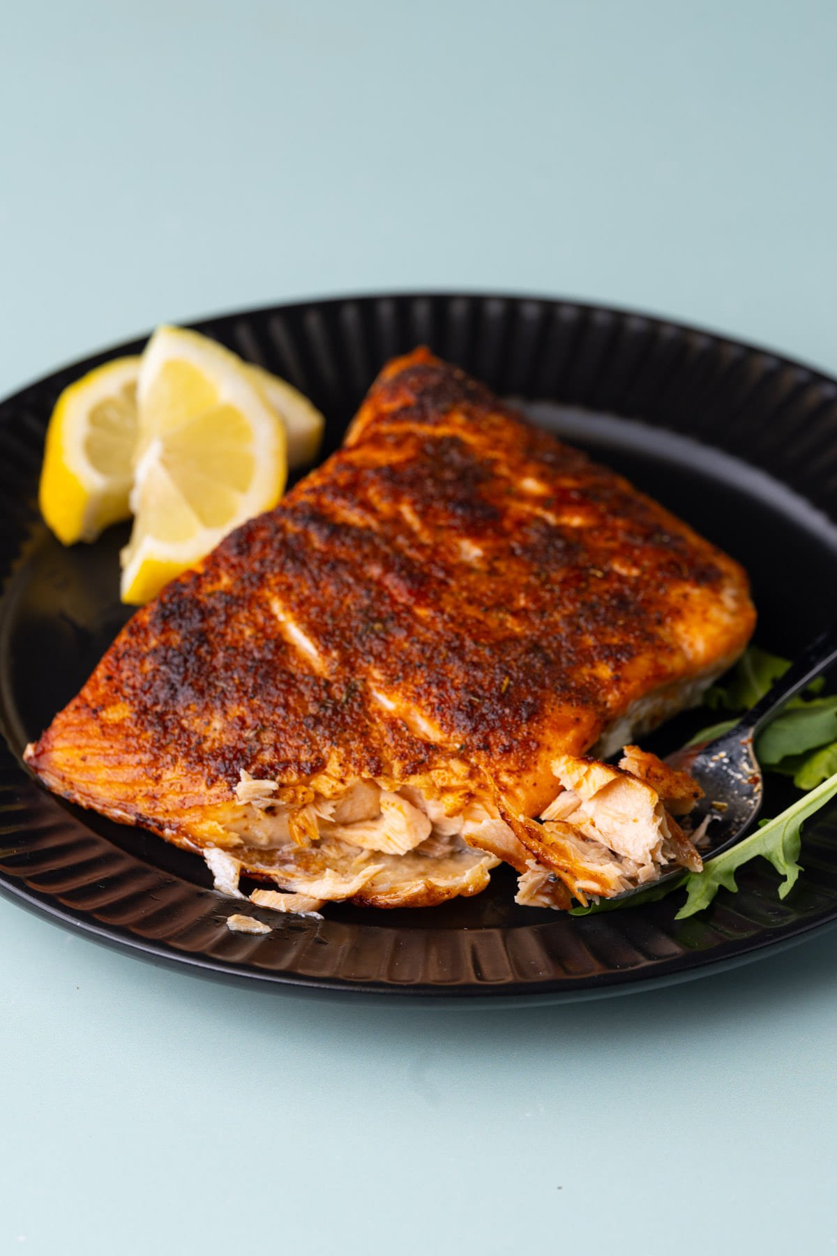 Cajun salmon with a forkful taken out to show the flaky texture. 