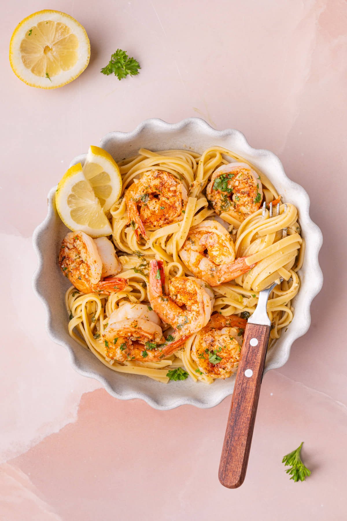 Overhead image of Cajun Shrimp Scampi plated with pasta with a fork stuck in the bowl with pasta twirled around it.