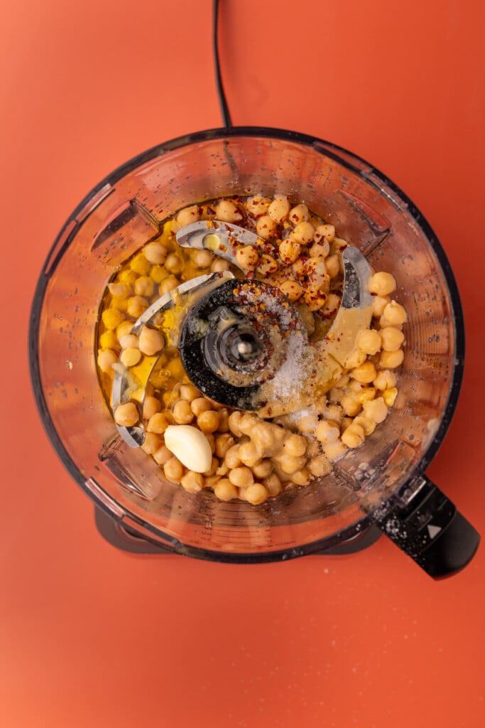 All ingredients for spicy hummus in a food processor ready to blend.