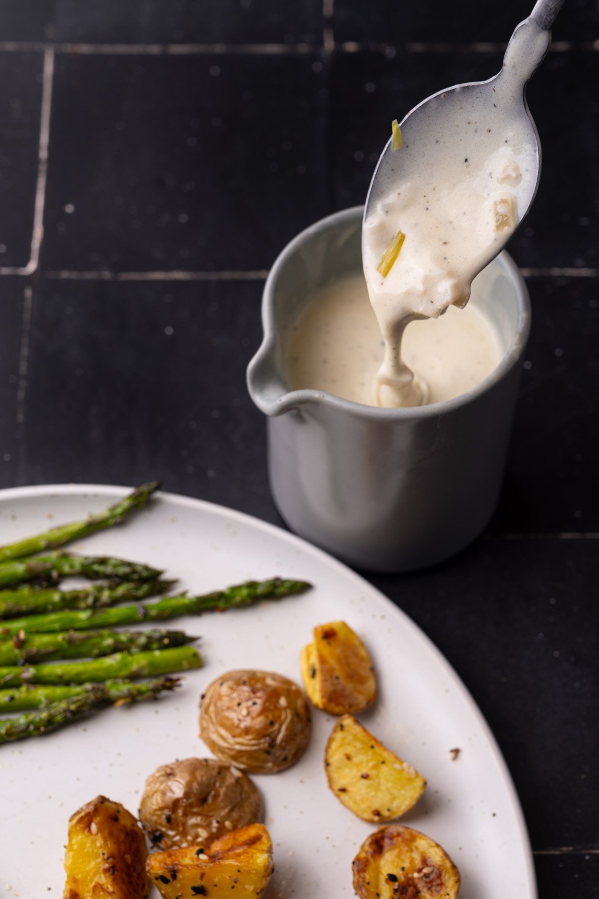 Sherry cream sauce dripping off spoon into creamer. 