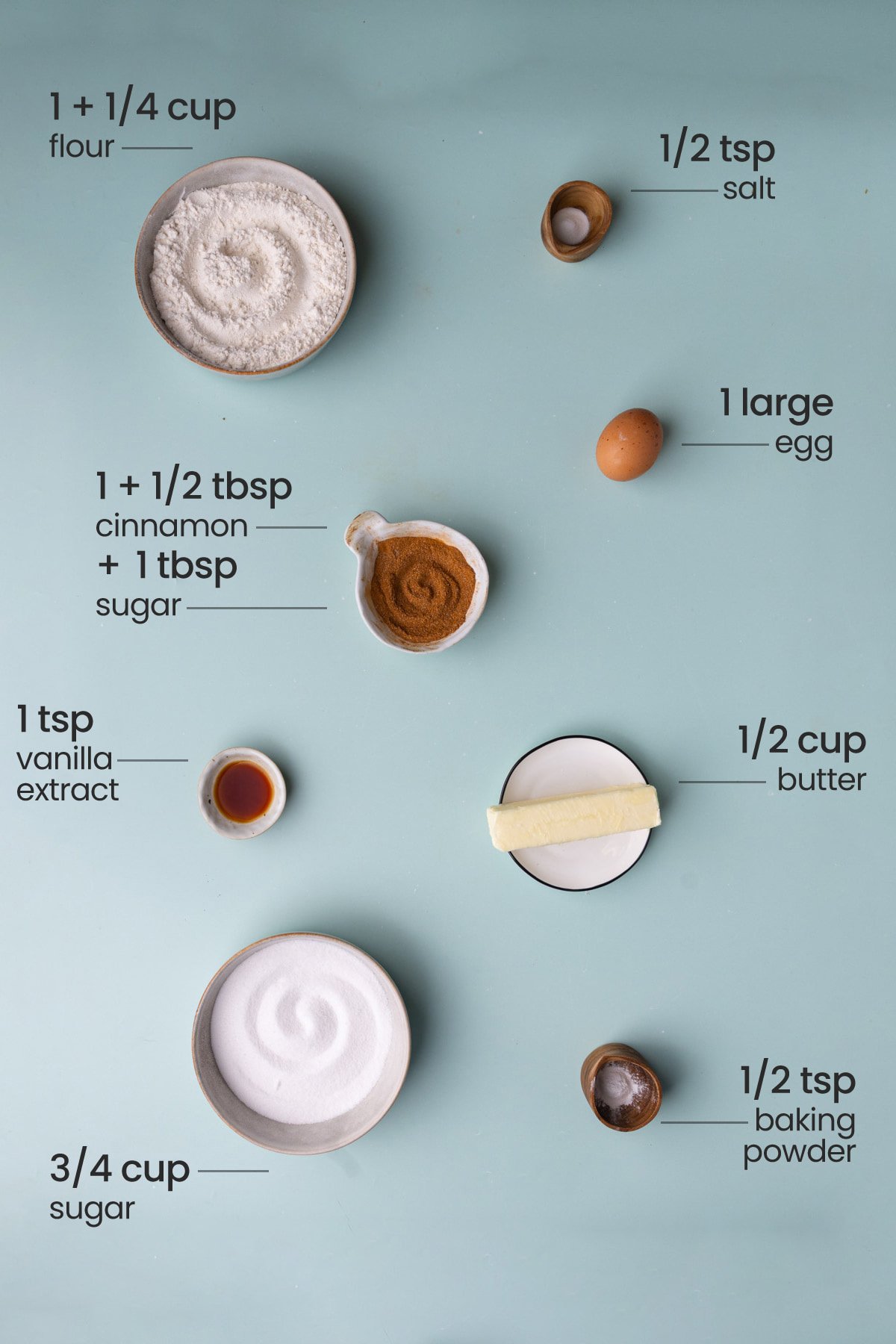 All the ingredients needed for snickerdoodles - flour, salt, egg, cinnamon, sugar, vanilla extract, butter, and baking powder.