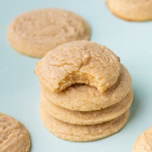 Stack of sugar cookies with brown butter with the top cookie having a bite taken out of it to show the texture.