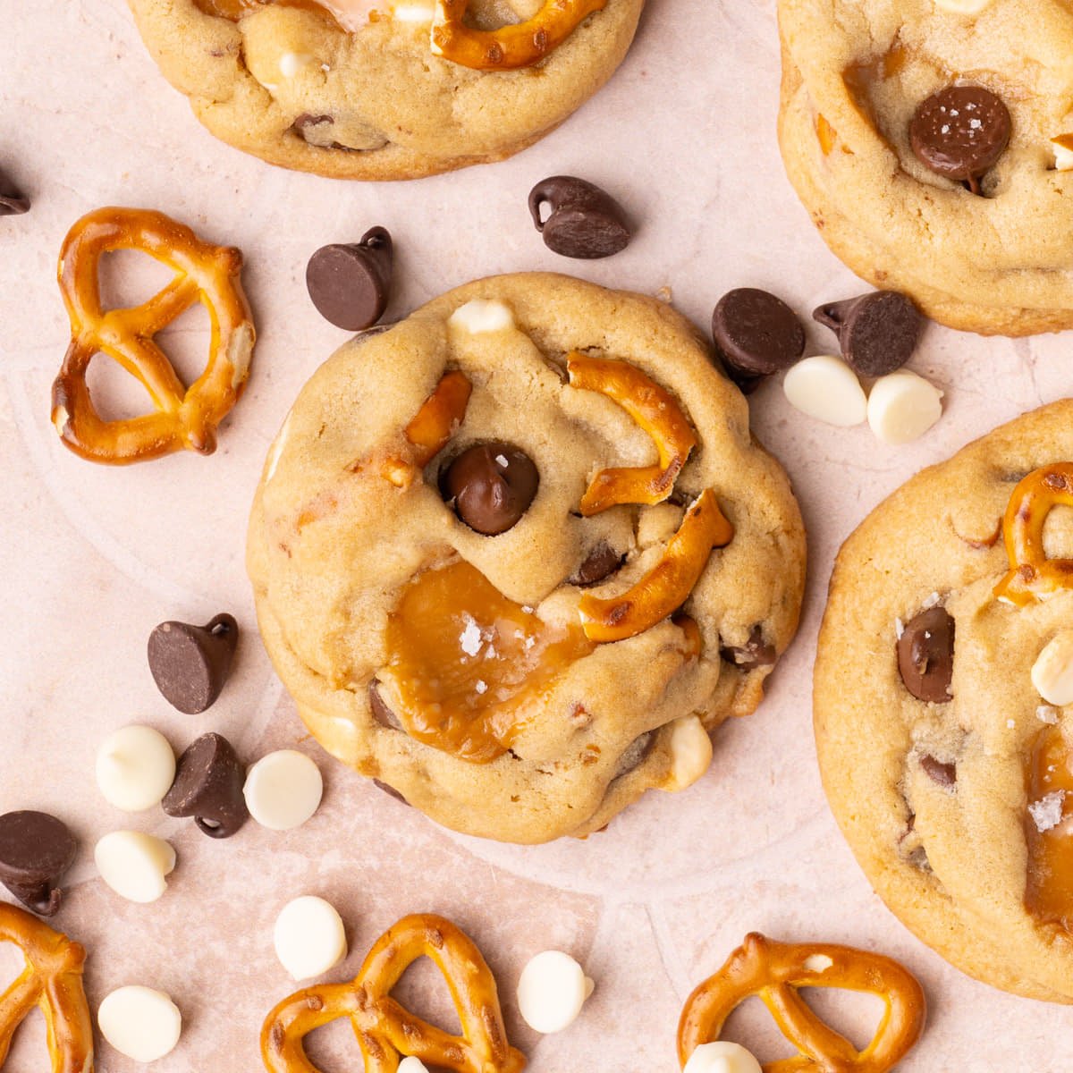 Close up of Everything but the Kitchen Sink Cookie surrounded by pretzels and white and dark chocolate chips.