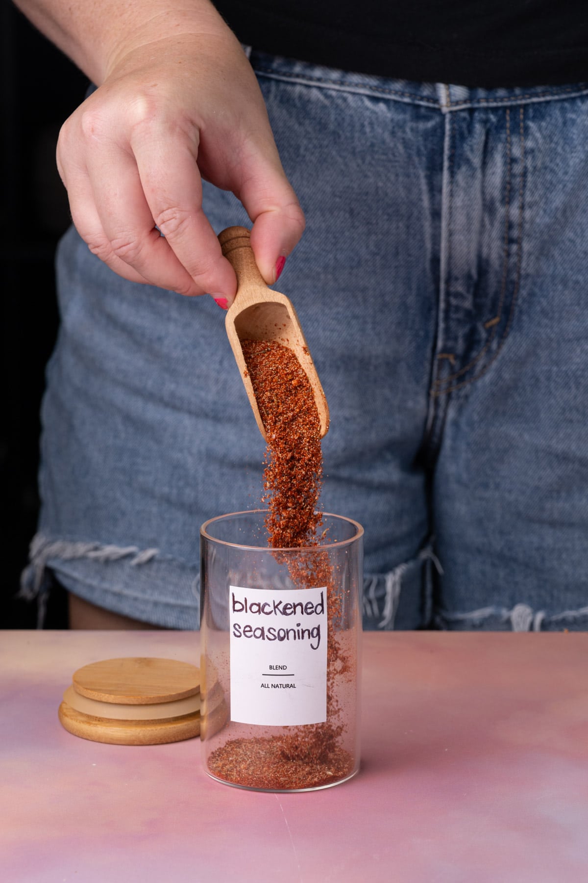 Transferring homemade blackened seasoning to a glass jar to store for later use.