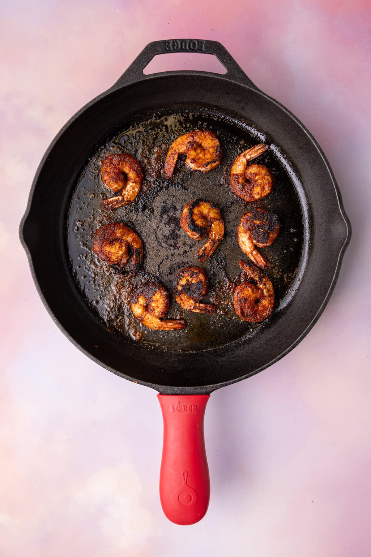Blackening shrimp in a cast iron skillet with olive oil.