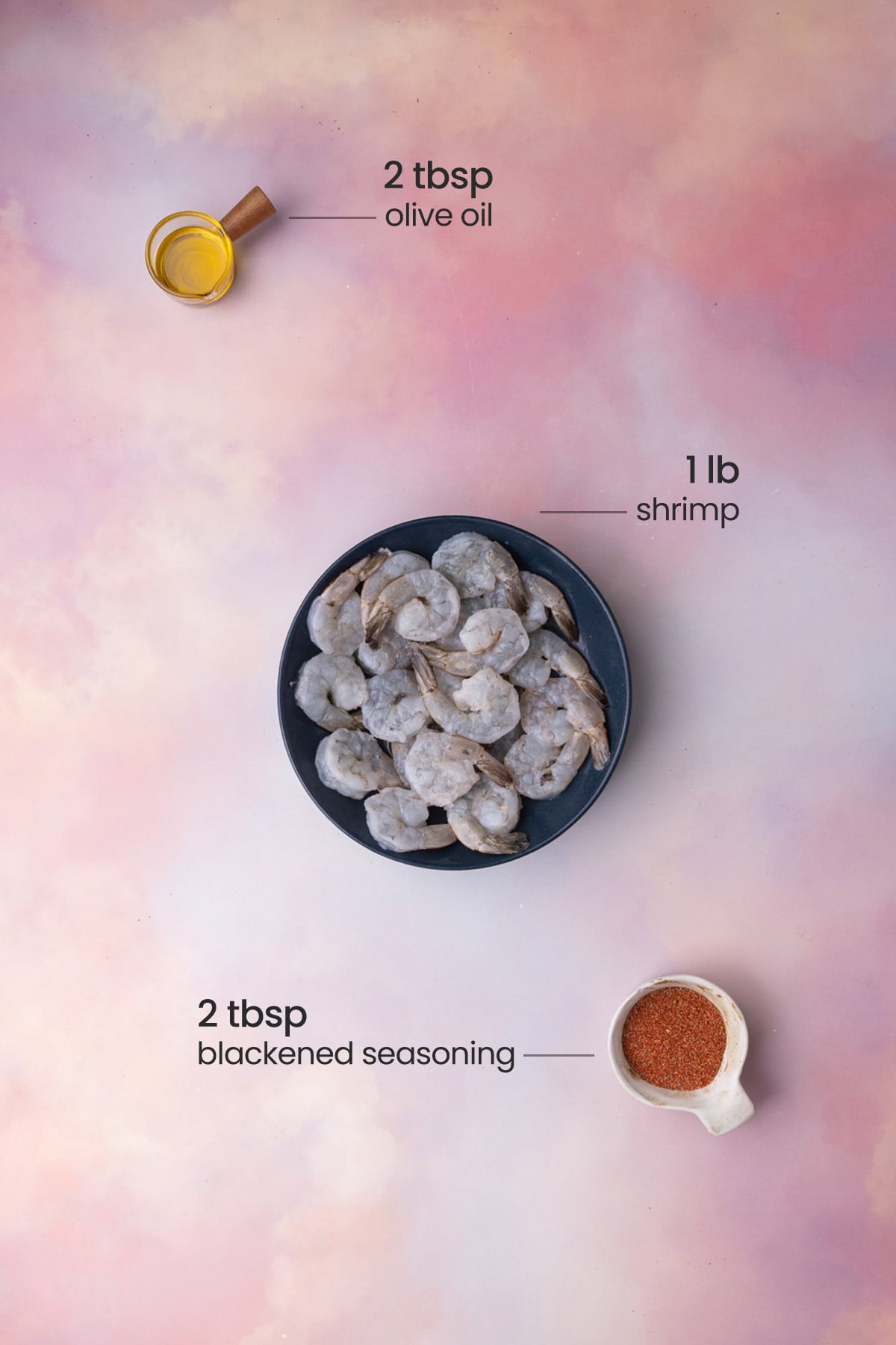 All ingredients needed for blackened shrimp including raw shrimp, blackened seasoning, and olive oil.