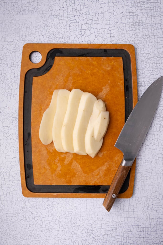 Peeled russet potatoes sliced thin vertically.