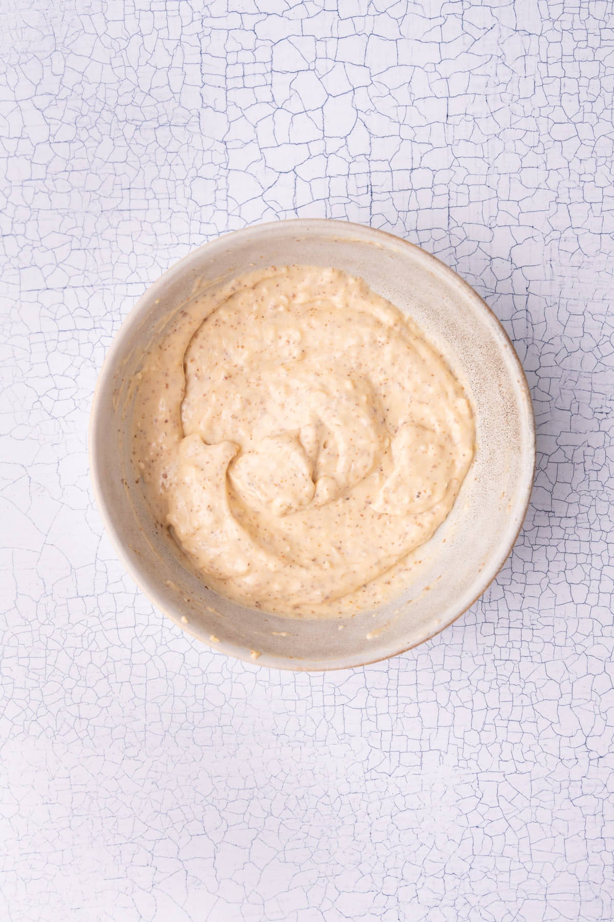 A bowl with mayonnaise, mustard, hot sauce, garlic, and Cajun seasoning all mixed together.