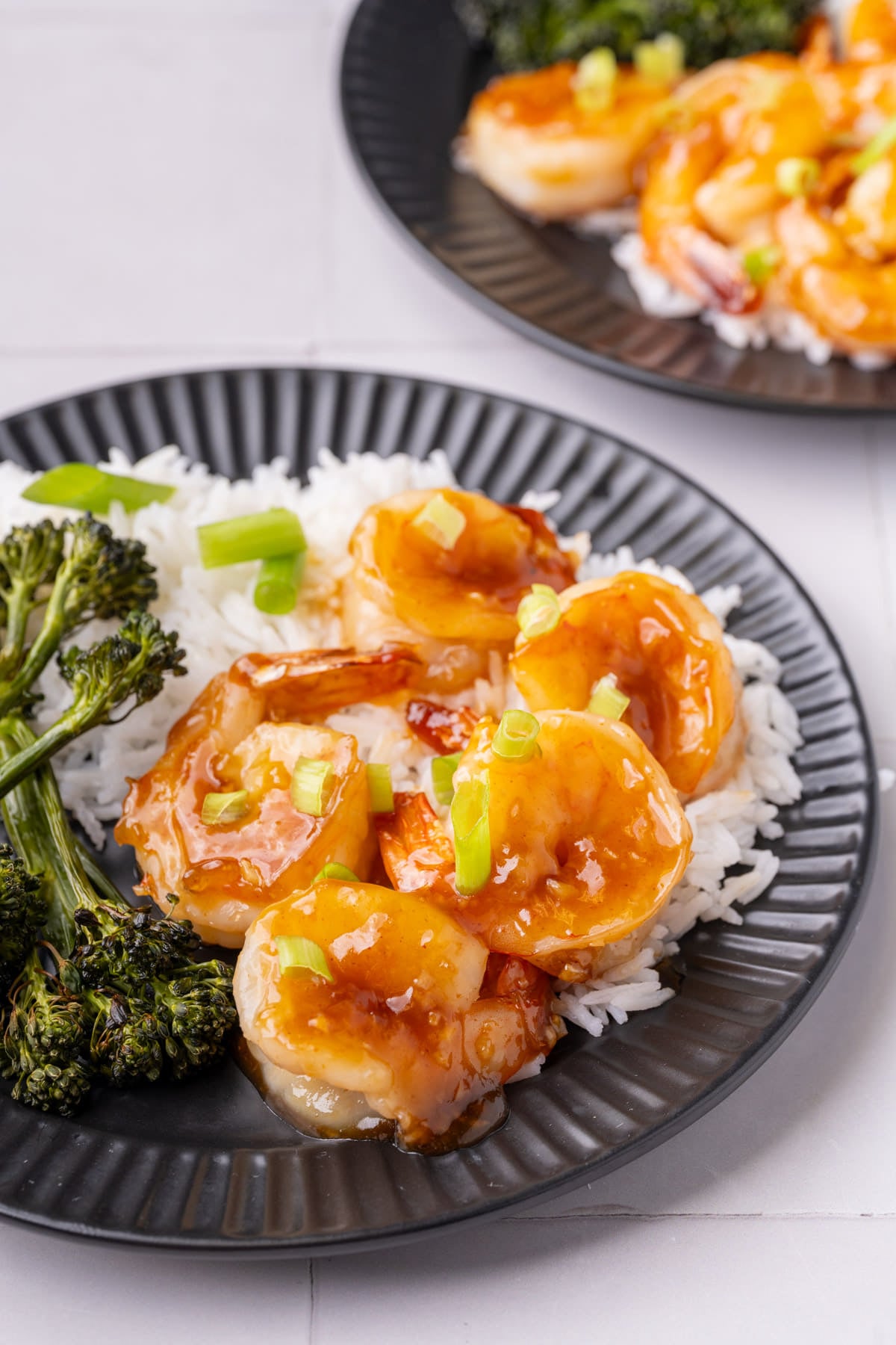 Close up image of honey garlic shrimp showing the sticky thick sauce that is completely coating the shrimp.