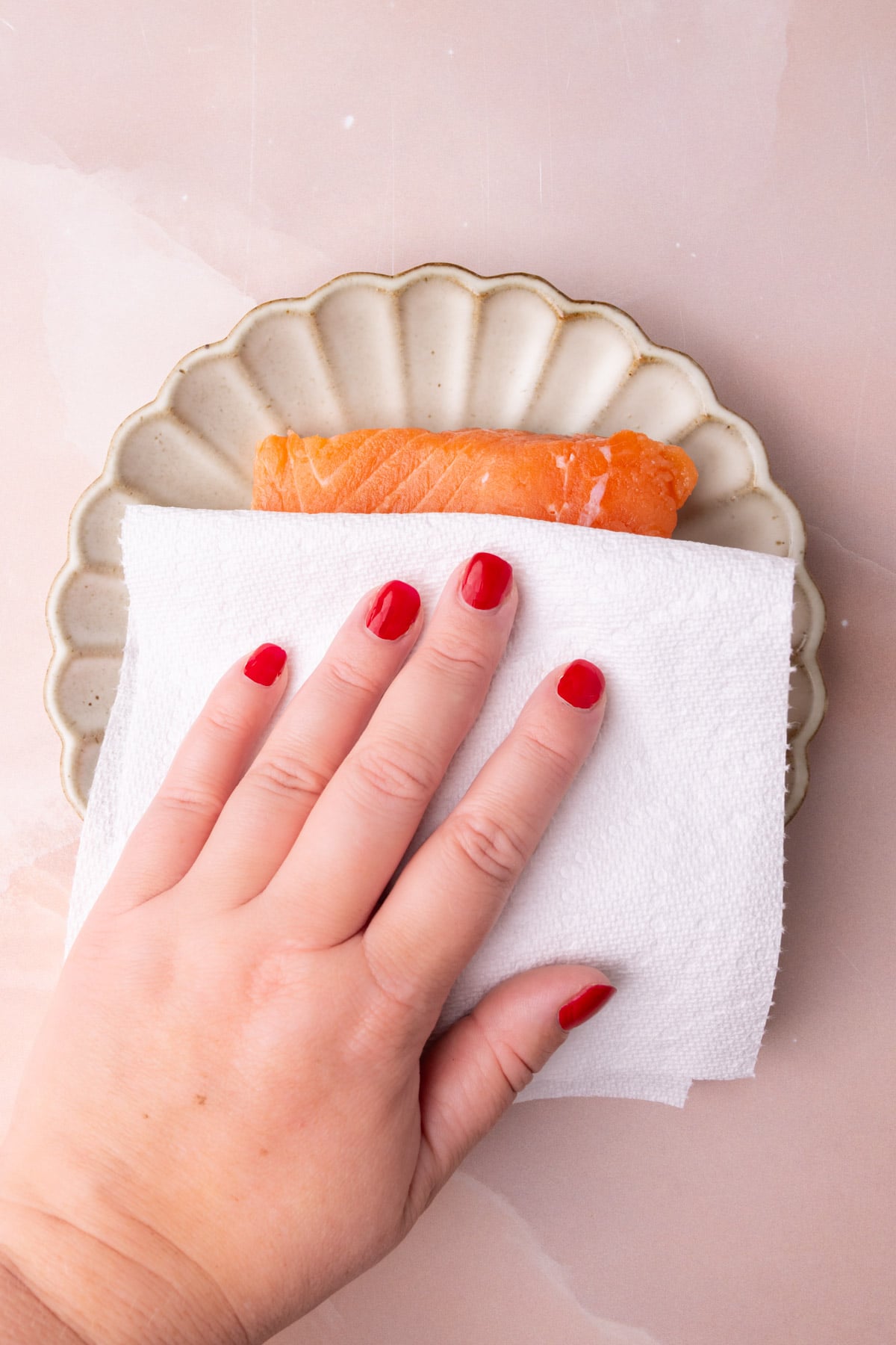 Blotting salmon dry with a paper towel for best texture after roasting.
