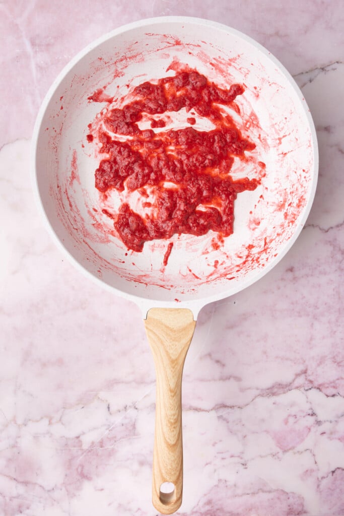 Strawberries reduced in a pan to resemble a strawberry puree.