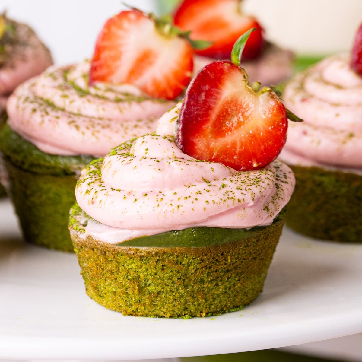 Matcha cupcakes topped with strawberry cream cheese frosting and finished with a fresh strawberry.