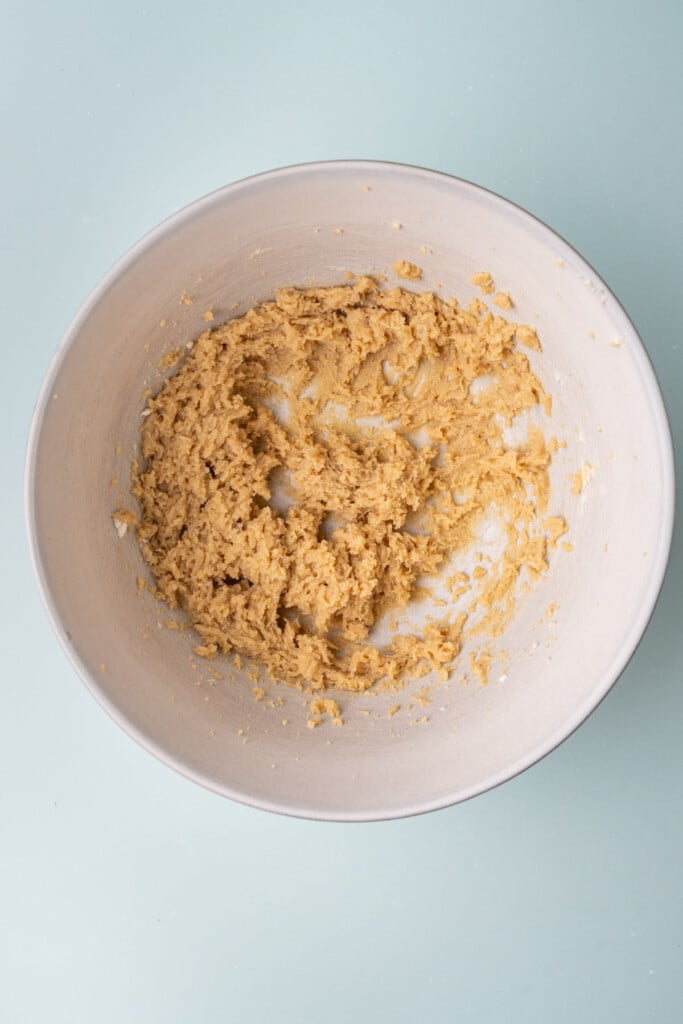 Light brown sugar and softened unsalted butter creamed together in a large mixing bowl.