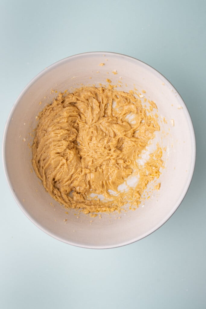 The beginnings of cookie dough in a large mixing bowl before adding the dry ingredients.