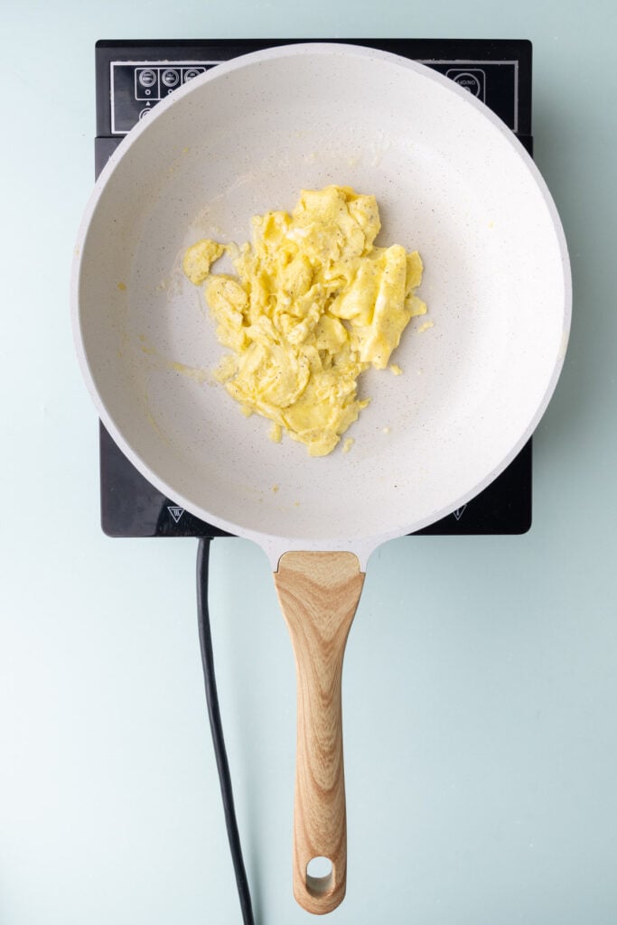 Eggs scrambled in a pan.