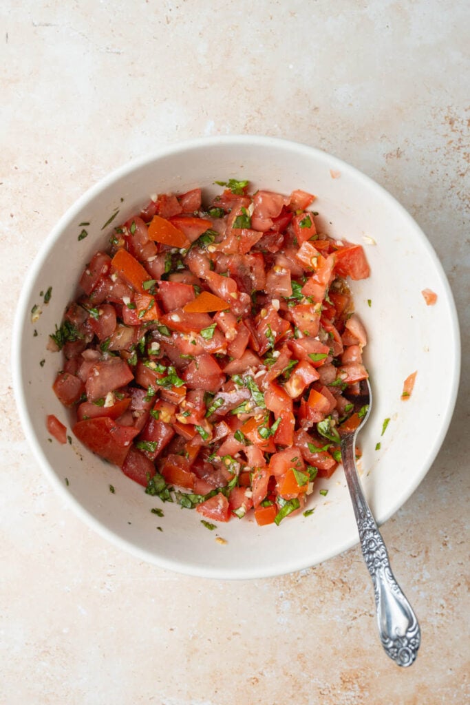Diced tomato mixed with minced garlic, diced basil, olive oil, salt, and pepper.
