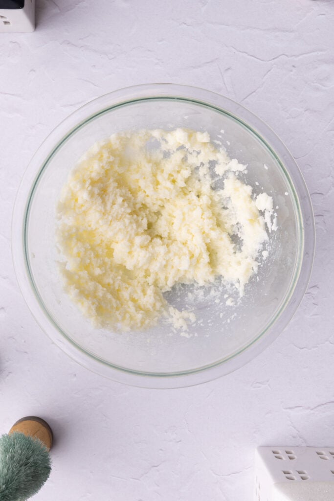 Butter and sugar creamed together until light and airy in a glass mixing bowl.
