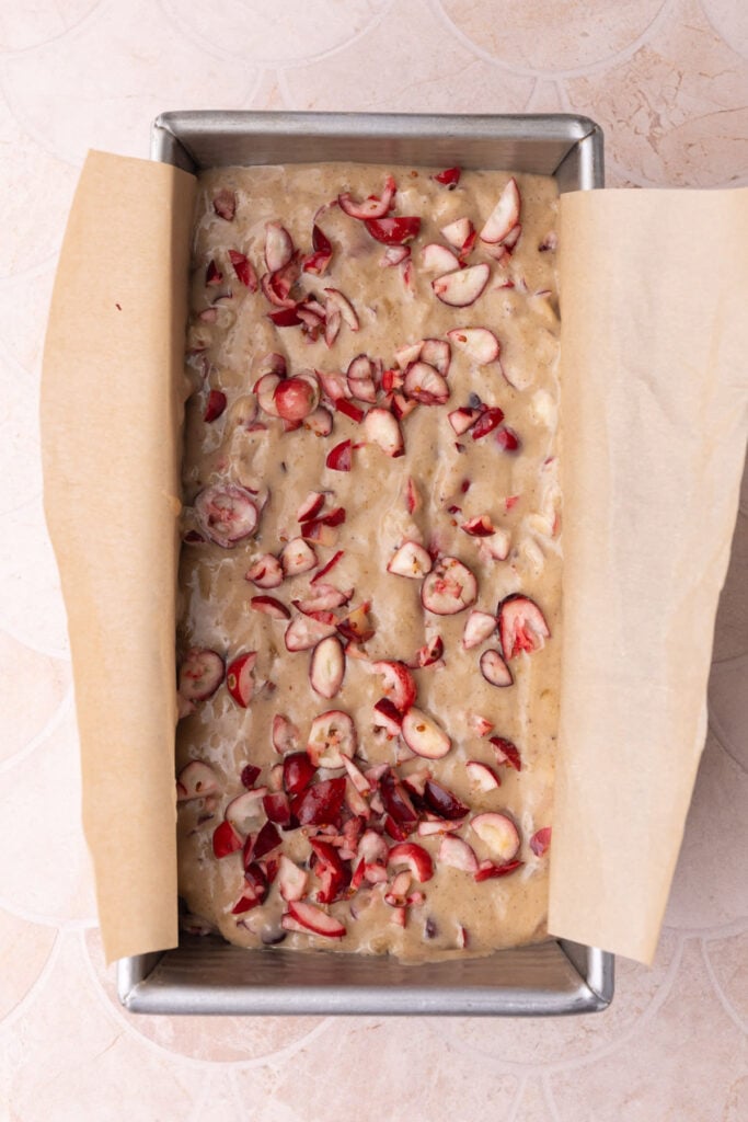 Cranberry banana bread with extra diced cranberries on top ready to bake in the oven.
